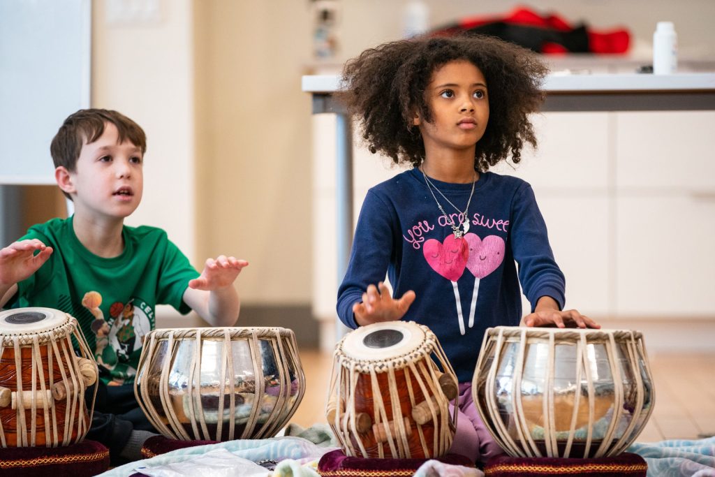 photo of two boys playing tabla drums.