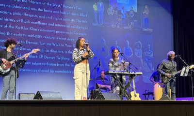 photo of 4 musicians and a vocalist performing on stage. Behind them, a large screen of text and images tell a story of the quote Harlem of the West unquote, Denver's Five Points neighborhood.