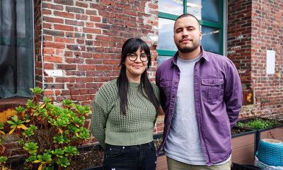 two people standing in front of a brick building