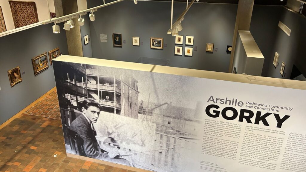 photo of a gallery space taken from high up in the room. various objects are hanging from the walls.