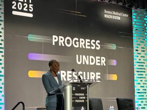 photo of Doctor Thea James speaking at a podium.