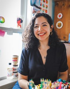 photo of a smiling artist in her studio