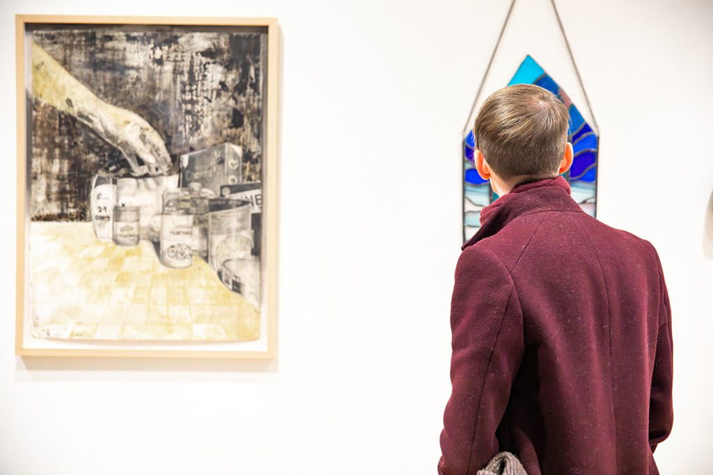photo of a person standing in a gallery looking at art