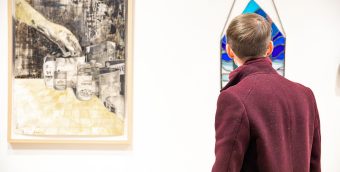 photo of a person standing in a gallery looking at art