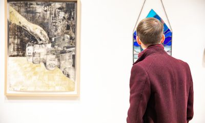 photo of a person standing in a gallery looking at art