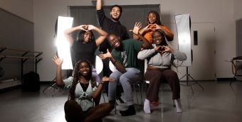 photo of half a dozen young people making happy gestures with their arms and faces.