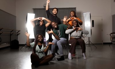 photo of half a dozen young people making happy gestures with their arms and faces.