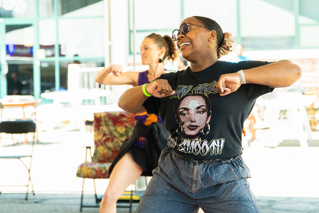 photo of 2 women dancing as part of a community dance event.