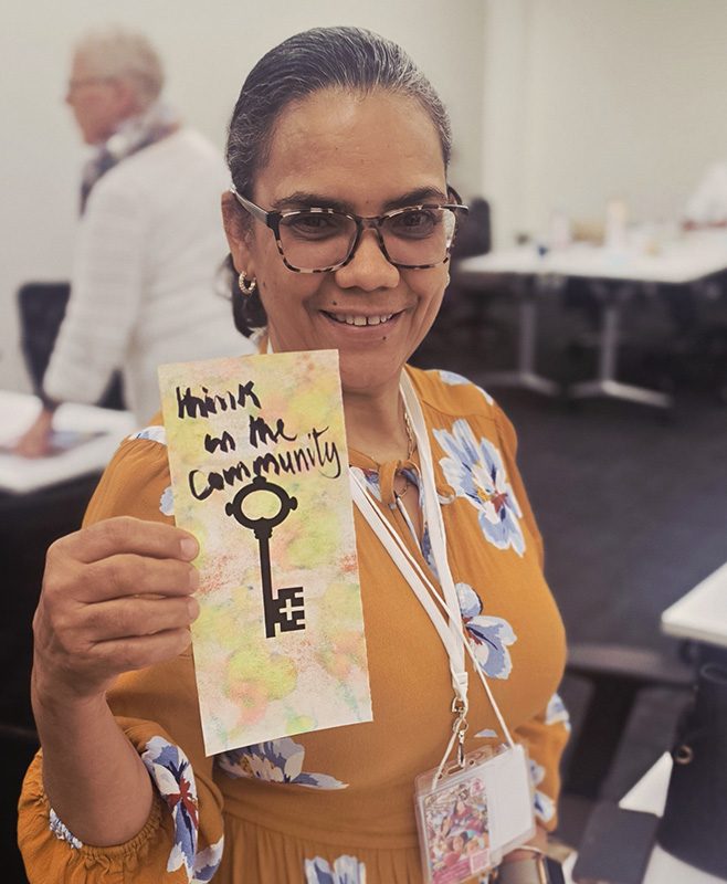 a women shows her contribution to a collage project.