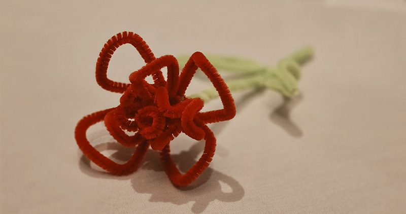 photo of a rose made from red and green pipe cleaners.