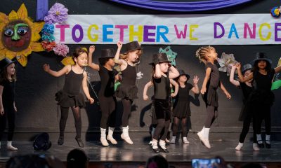 photo of a dozen young dancers performing under a banner that says together we dance.