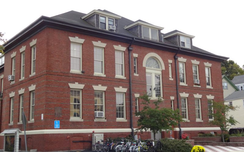A three-story brick building with bicycles parked by the entrance