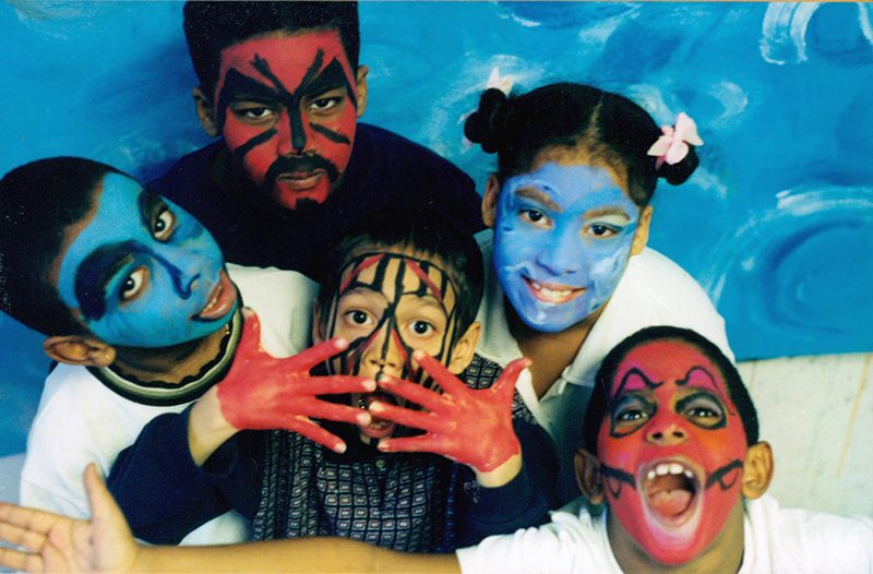 portrait of 5 young people each with vibrantly painted faces.